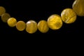 Yellow necklace made of round flat beads on a dark background Royalty Free Stock Photo