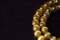 Yellow necklace of stone beads cat`s eye on a dark background Royalty Free Stock Photo