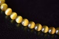 Yellow necklace of stone beads cat`s eye on a dark background Royalty Free Stock Photo
