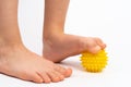 yellow needle ball for massage and physical therapy on a white background with a child& x27;s foot, the concept of Royalty Free Stock Photo