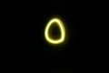 Circle-oval shaped yellow neon light suspended in black space