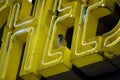 Yellow neon sign with bird sitting perched high up