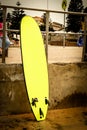 A yellow neon surf board lied on the fence and floor in front of the Bondi Beach in Sydney, Australia Royalty Free Stock Photo