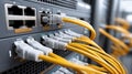 Yellow network cables are connected to the back panel of a server rack in a dark setting, highlighting the intricate details