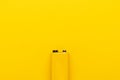 Blank nine-volt battery on the yellow background with copy space Royalty Free Stock Photo