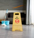 A yellow `NO ENTRY` sign place on the floor in hotel room. While cleaning. A mop and a bucket of water in the background Royalty Free Stock Photo