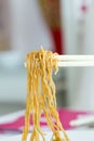 Yellow noodles with chopstick holding Royalty Free Stock Photo