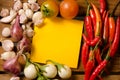Yellow note with chilli,tomato,shallot and garlic on wood background