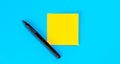 Yellow note with empty place for text with marker on blue background, flat lay. Royalty Free Stock Photo