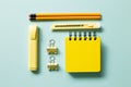 Yellow note pad, pencil, highlighter, cutter, clip on blue background. workspace Royalty Free Stock Photo