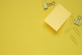 yellow note pad stick on yellow paper against group of yellow binders clips, top view, flat lay Royalty Free Stock Photo