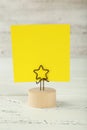 Yellow note paper on a holder on wooden background Royalty Free Stock Photo