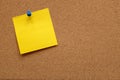 Yellow note paper pinned to a cork board Royalty Free Stock Photo