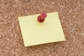 Yellow Note Paper With Tack on Cork Surface Royalty Free Stock Photo