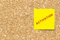 Yellow note paper with word activation on cork board with copy space Royalty Free Stock Photo