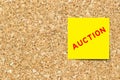 Yellow note paper with word auction on cork board Royalty Free Stock Photo