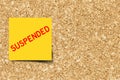 Yellow note with word suspended on cork board background Royalty Free Stock Photo