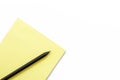 Yellow notebook and black pencil on a white background. Minimal business concept. Royalty Free Stock Photo