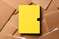 Yellow notebook on brown kraft notebook disorder alignment on table background.mockup template for display content or design.
