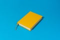 Yellow notebook over blue background in perspective