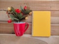 Yellow notebook, red cup and flower on wood background Royalty Free Stock Photo
