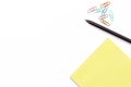 Yellow Notepad, black pen and colorful paper clip on white background. Minimal working concept for office, school, university. Fla Royalty Free Stock Photo