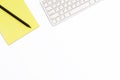 Yellow Notepad, computer keyboard and black pencil on a white background. Minimal business concept of working place in the offices Royalty Free Stock Photo