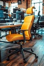 A yellow office chair with a black back and black wheels sits in front of a desk Royalty Free Stock Photo