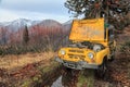 Offroad all terrain car stuck after breakdown under repair on mountain forest road. Autumn scenic landscape Royalty Free Stock Photo