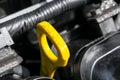 Yellow oil dipstick in car engine. Measuring level of engine oil. Dipstick oil level gauge with yellow color for Checking engine o Royalty Free Stock Photo