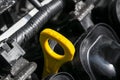 Yellow oil dipstick in car engine. Measuring level of engine oil. Dipstick oil level gauge with yellow color for Checking engine o Royalty Free Stock Photo