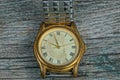 yellow old shabby watch with a metal strap on a gray table Royalty Free Stock Photo