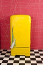 Yellow old vintage retro refrigerator on a pink background with Royalty Free Stock Photo