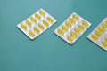 Yellow Omega 3 capsules in blisters lying in a row on a green background. Fish oil, dietary supplement, drugs, medicine Royalty Free Stock Photo