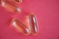 Yellow omega 3 fish oil pills on a red background