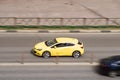 Yellow Opel astra gtc on the city road. Fast moving car on Moscow streets. Vehicle driving along the street in city with blurred