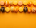 Yellow, orange, beige, black macaroons on yellow background. Autumn concept