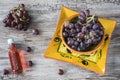 Bunch of red grapes in orange bowl, against wooden background Royalty Free Stock Photo