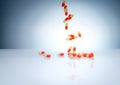 Yellow-orange capsules pill falling down on white table. Pharmaceutical industry. Drug interactions, side effect, and adverse drug Royalty Free Stock Photo