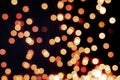 Yellow and orange Christmas tree bokeh on black background of defocused glittering lights, Christmas background pattern concept Royalty Free Stock Photo