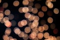 Yellow and orange Christmas tree bokeh on black background of defocused glittering lights, Christmas background pattern concept Royalty Free Stock Photo