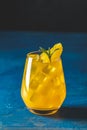 Yellow orange cocktail with tangerine and rosemary in glass on dark blue concrete background, close up Royalty Free Stock Photo