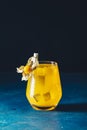 Yellow orange cocktail with tangerine and rosemary in glass decorated Physalis peruviana on dark blue concrete background , close Royalty Free Stock Photo