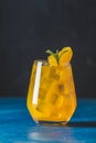 Yellow orange cocktail with tangerine and rosemary with ice in glass on dark blue concrete background , close up. Christmas and Royalty Free Stock Photo