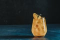 Yellow orange cocktail with tangerine and rosemary with ice in glass on dark blue concrete background , close up. Christmas and Royalty Free Stock Photo