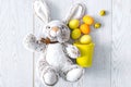 Yellow and orange easter chicken eggs in decor bucket with rabbit bunny toy, spring, easter flat lay concept Royalty Free Stock Photo