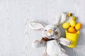 yellow and orange easter eggs in decor bucket with rabbit toy, spring, easter concept on wooden background Royalty Free Stock Photo