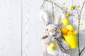 Yellow and orange easter painted chicken eggs in decor bucket with rabbit bunny toy, willow branches, spring, easter concept on Royalty Free Stock Photo