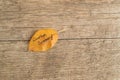 Yellow or orange leaf with inscription GOODBYE SUMMER on the wooden background Royalty Free Stock Photo