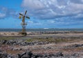 A yellow, orange painted iron windmill along the south coast on Bonaire.